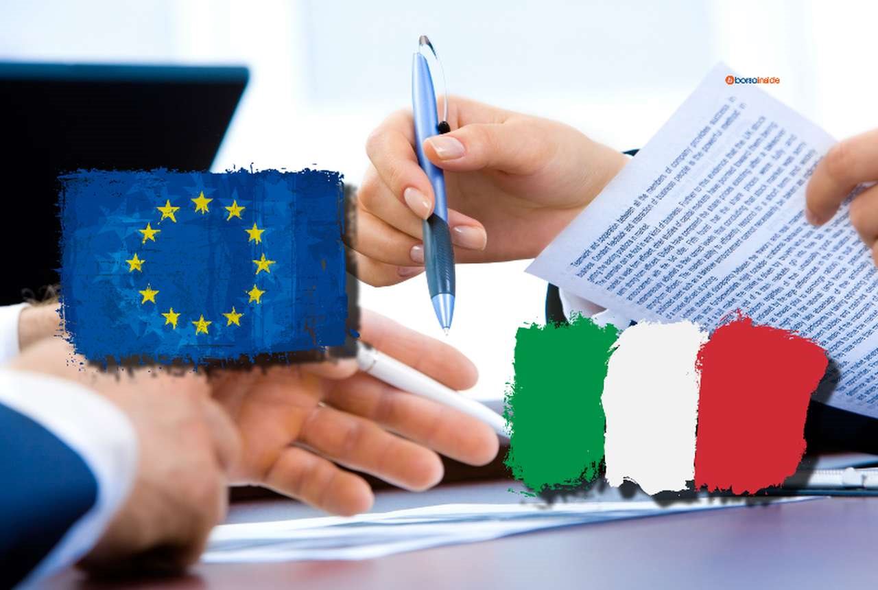 La bandiera dell'Ue e quella dell'Italia mentre sullo sfondo vengono apposte firme su alcuni documenti
