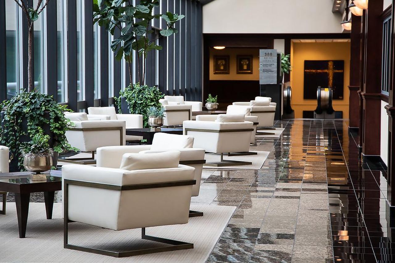 hall di un albergo di lusso con poltrone bianche e piante decorative