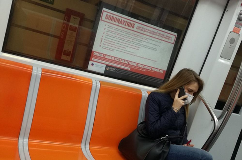 donna seduta in metro con indosso la mascherina