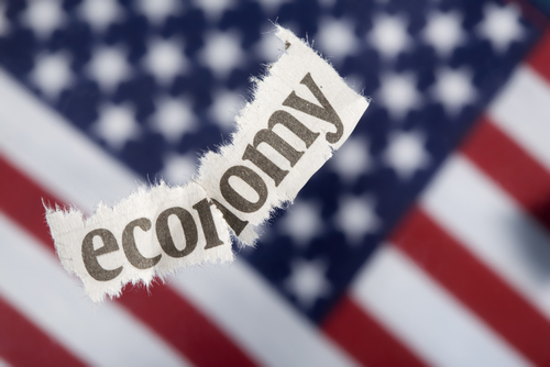 strisciolina di carta con scritta 'economy' con bandiera USA come sfondo
