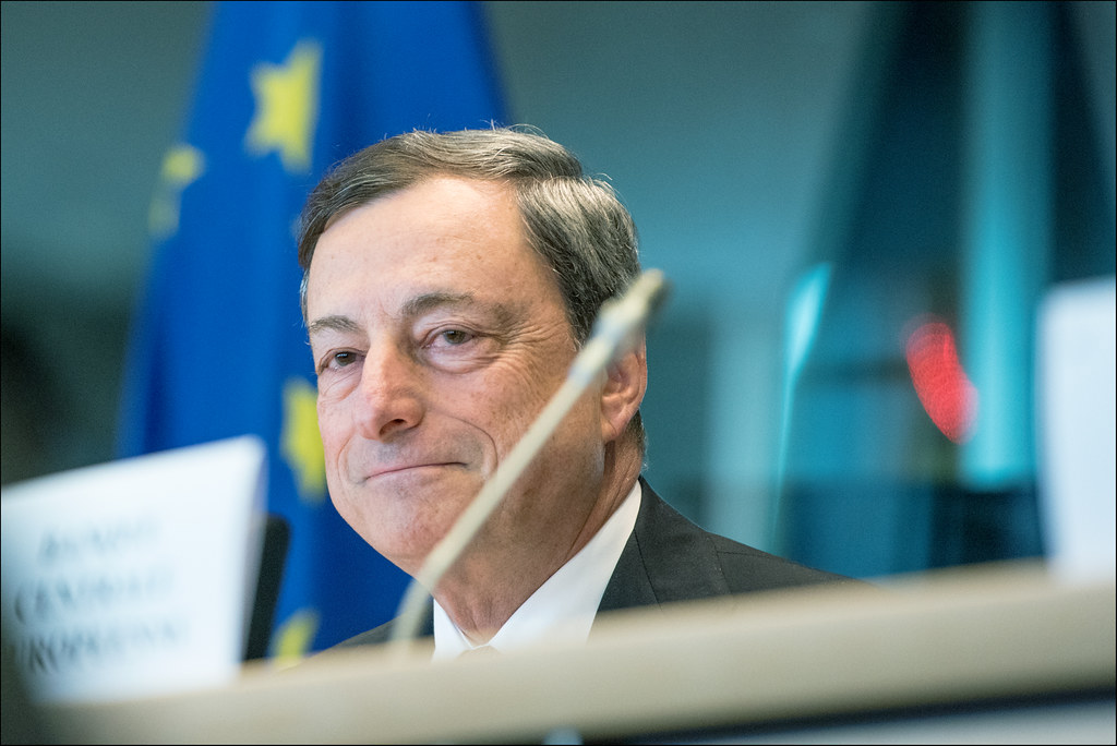 volto di Mario Draghi con bandiera Ue alle sue spalle