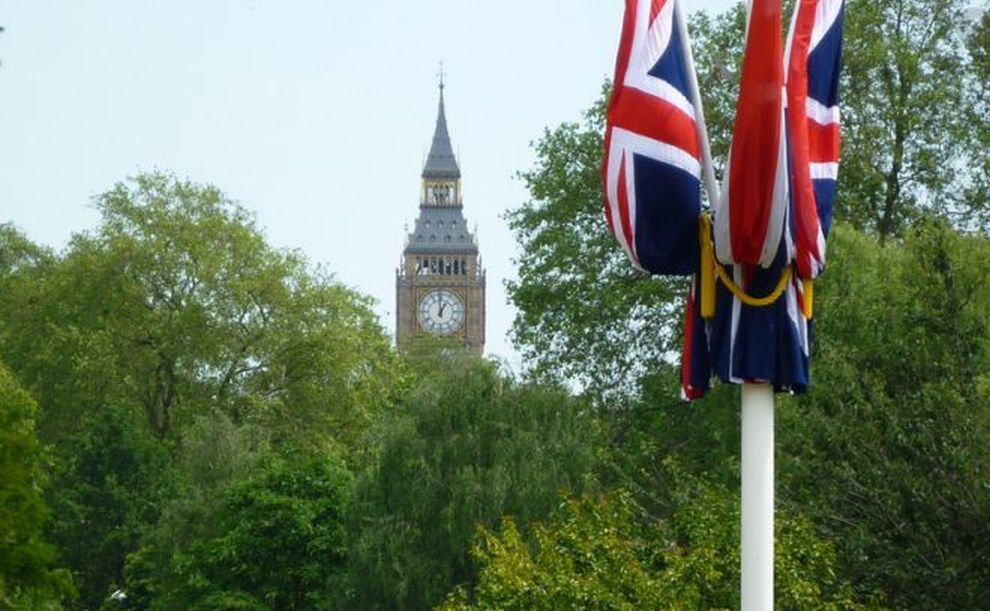 bandiera del Regno Unito svetta tra gli alberi e dietro spunta il Big Ben