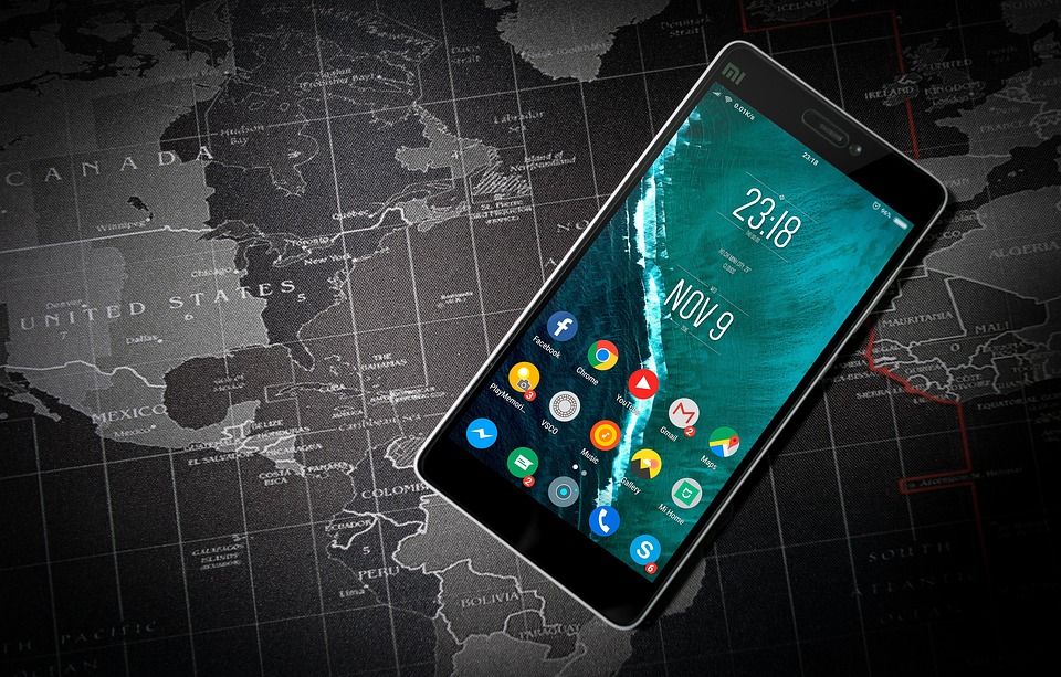 uno smartphone acceso poggiato su una cartina geografica