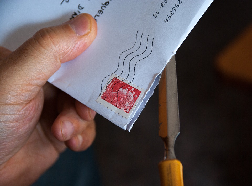 una busta da lettera che viene aperta con un tagliacarte