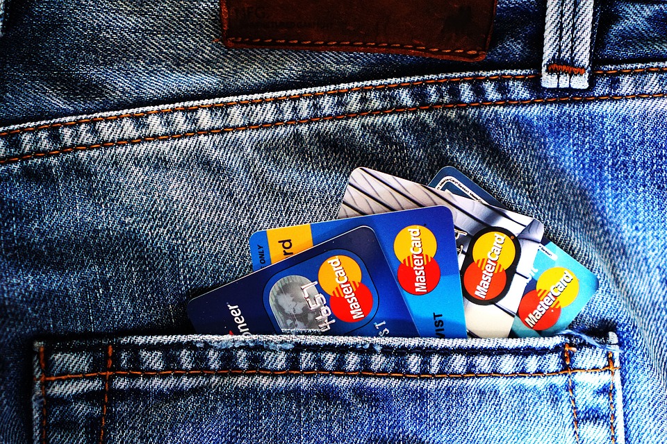 alcune carte di credito che emergono dalla tasca posteriore di un paio di pantaloni jeans