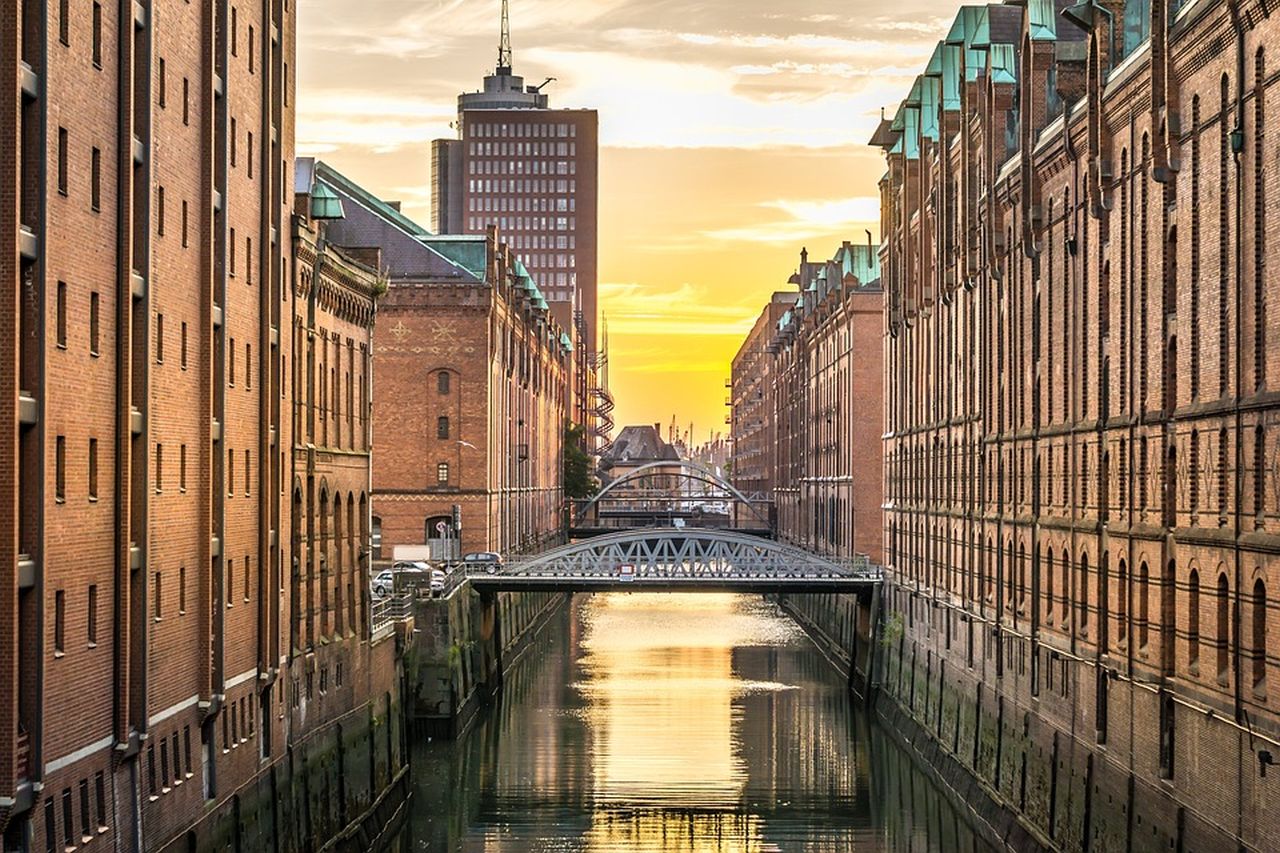Gli edifici di una grande città che si affacciano su un canale con un ponte moderno che collega le due sponde