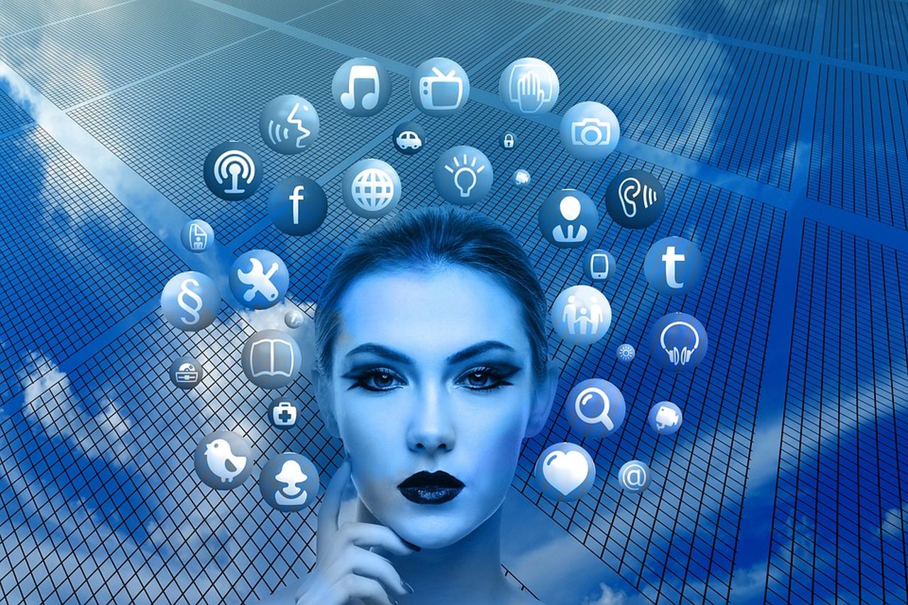 il volto di una donna con le icone di varie app intorno ad esso, con cielo e nubi nello sfondo, il tutto in toni di blu