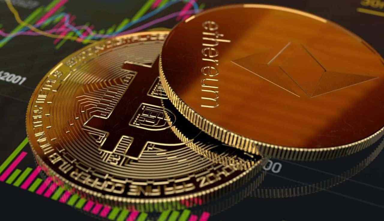 un gettone di Ethereum e uno di Bitcoin poggiati su un grafico sull'andamento dei prezzi