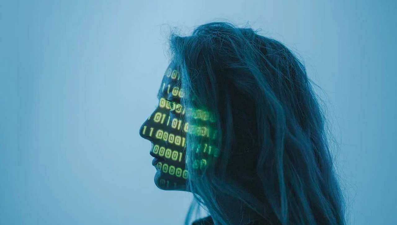 il profilo di una donna con dati in cifre e numeri luminosi che le attraversano il volto