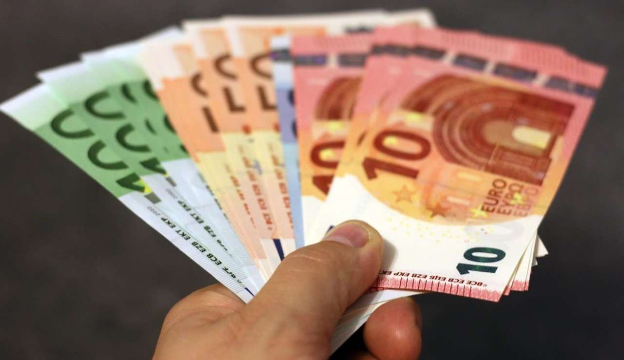 alcune banconote di euro di diverso taglio aperte a ventaglio con una mano