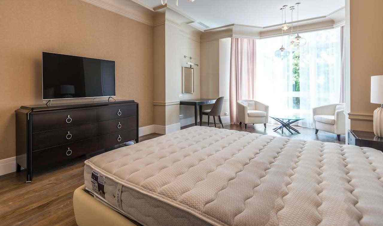 un letto con materasso scoperto in una stanza d'albergo