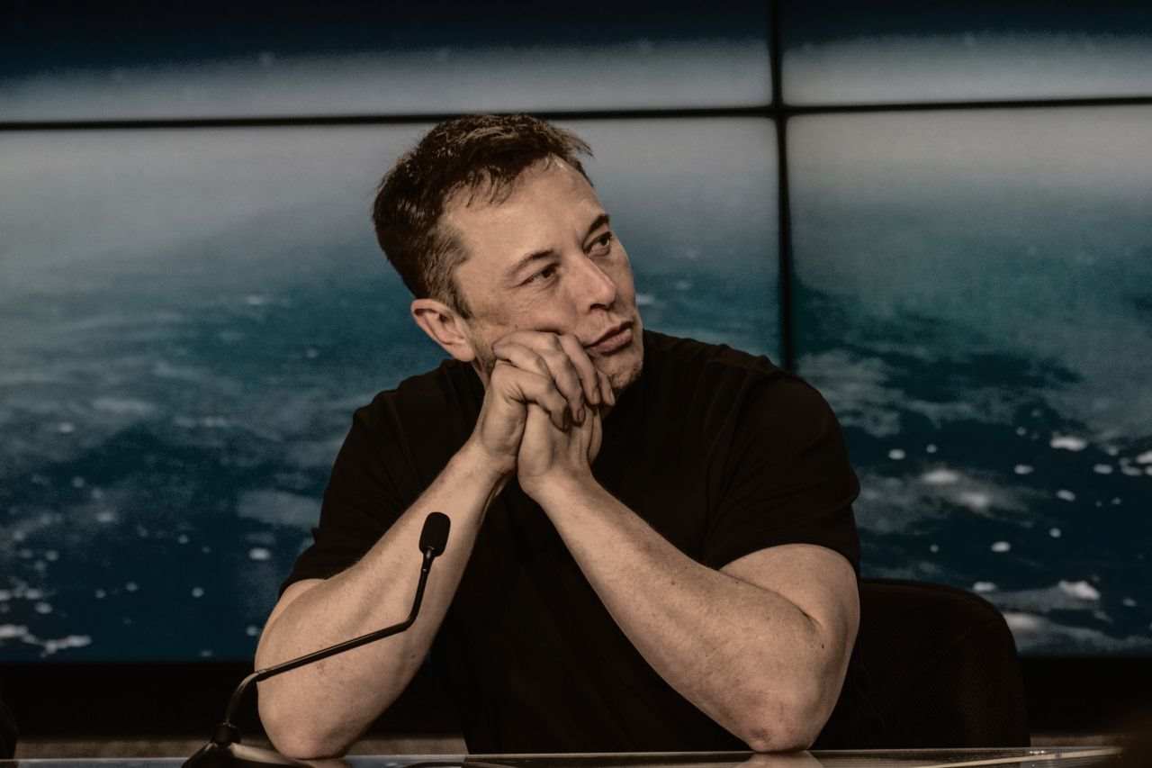 Elon Musk davanti al microfono in uno studio televisivo
