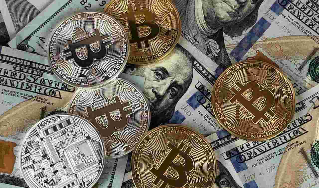 alcune monete di Bitcoin sparse su alcune banconote di dollari Usa