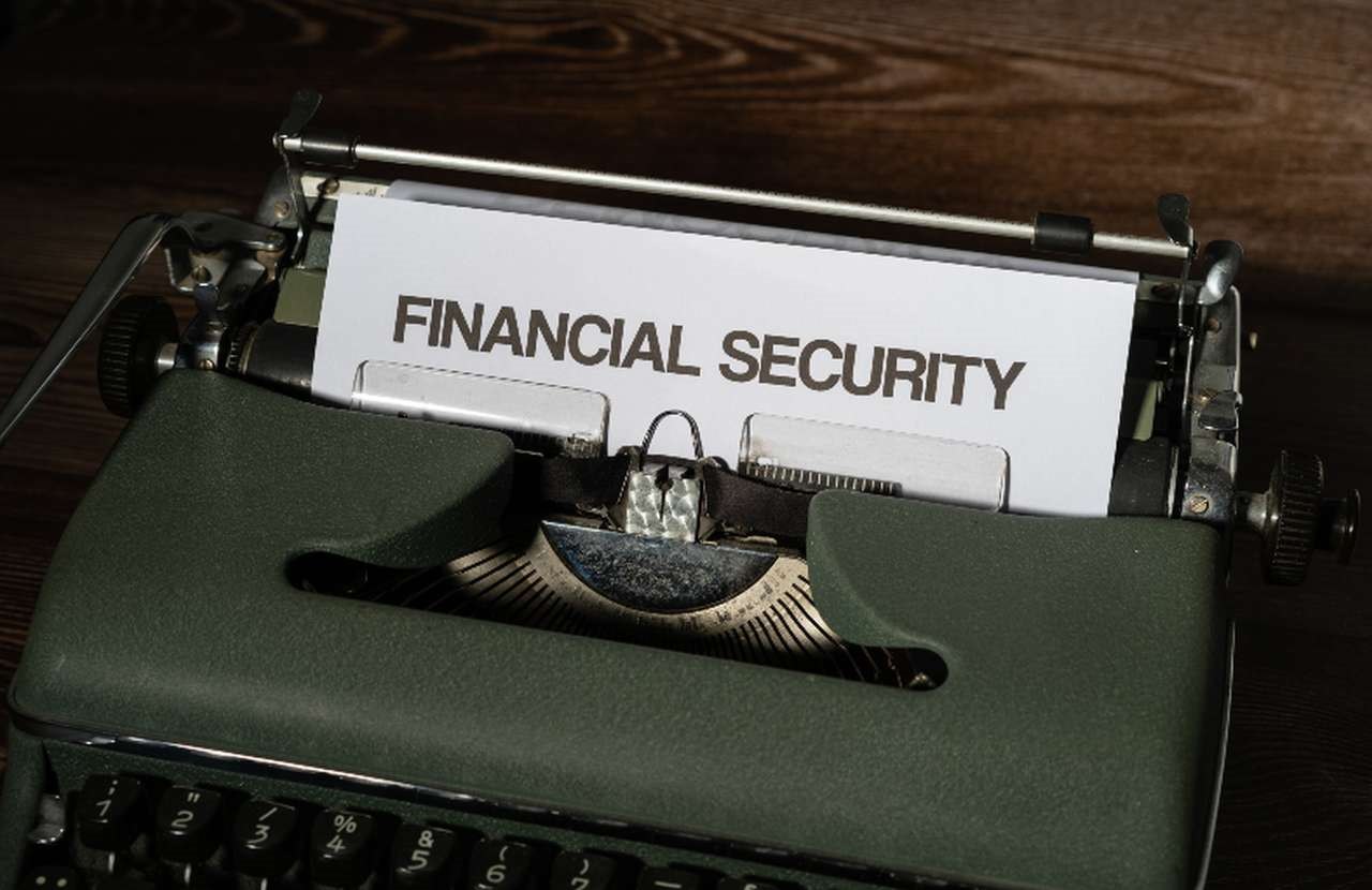 una macchina da scrivere da cui emerge un foglio con la scritta "Financial Security"