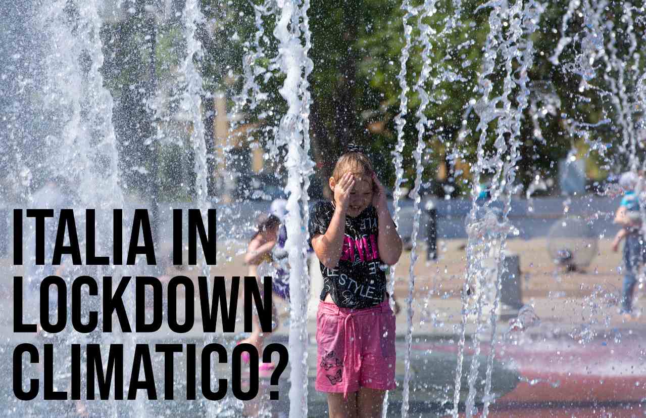 una ragazzina che si rinfresca grazie ai getti di una fontana nel parco