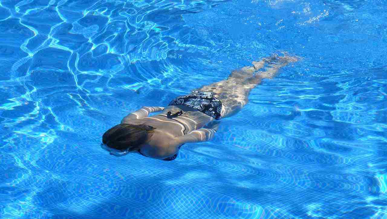 una donna che nuota in piscina