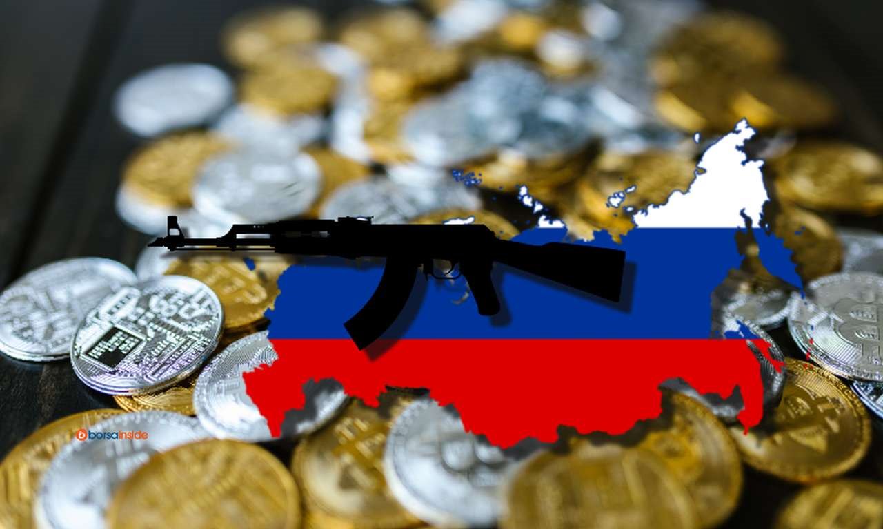 la cartina della Russia coi colori della bandiera nazionale, un Kalashnikov e svariate monete di Bitcoin nello sfondo