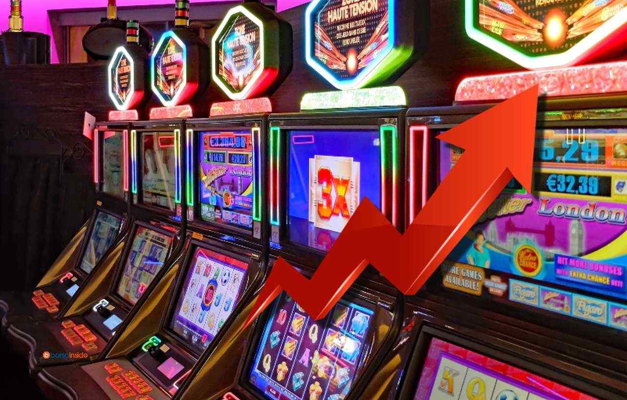 Alcune slot machines in un casino, e una freccia in sovrimpressione