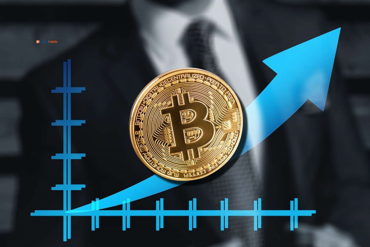 un grafico con sullo sfondo il busto di un uomo in giacca e cravatta e una moneta di Bitcoin in sovrimpressione