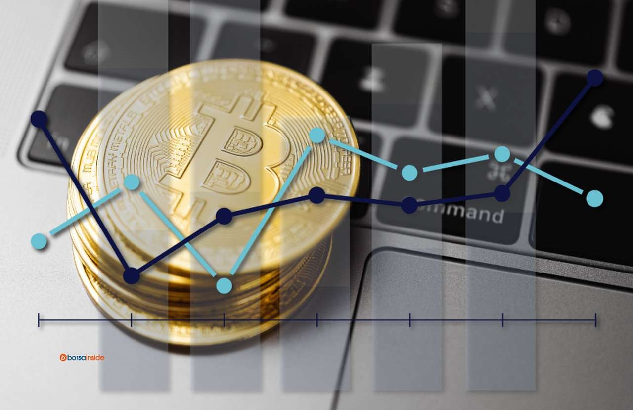 alcune monete di Bitcoin poggiate sulla tastiera di un laptop