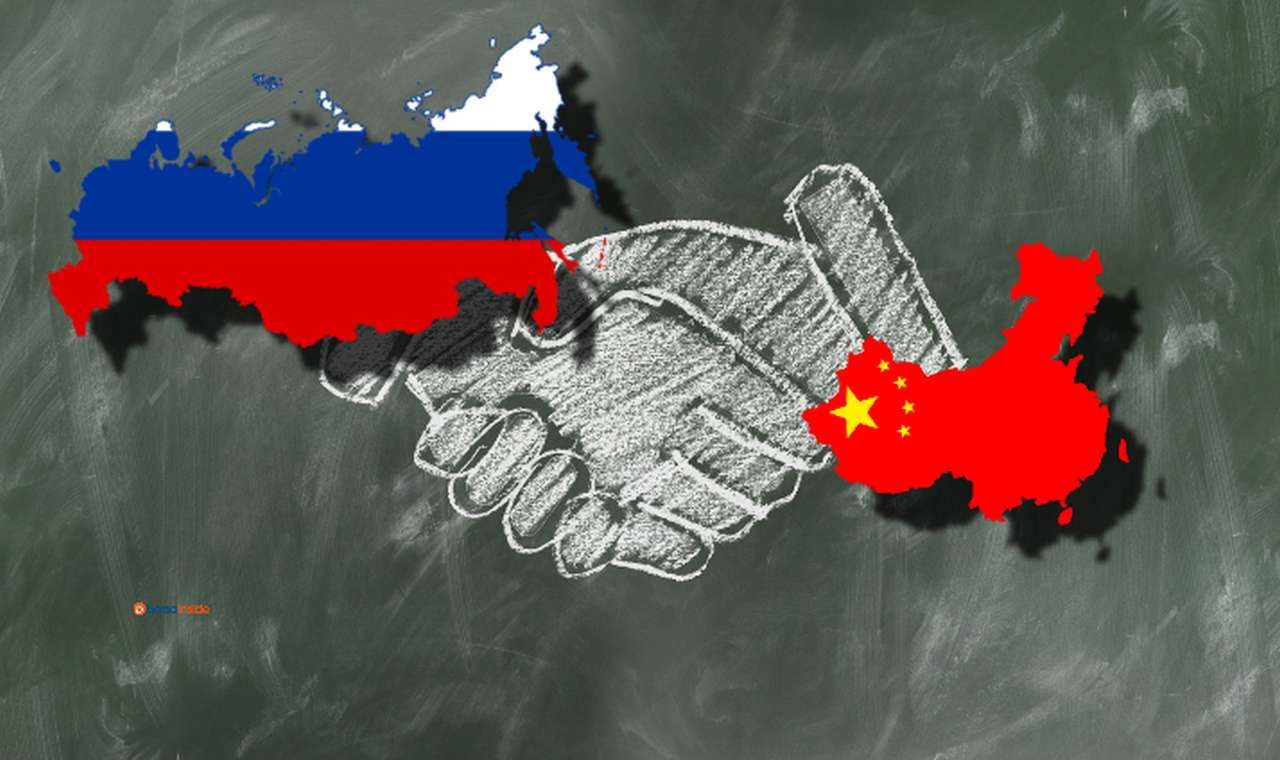 il disegno stilizzato, fatto coi gessetti su una lavagna, di due mani che si stringono. Le bandiere di Russia e Cina racchiuse nei confini dei rispettivi Stati in sovrimpressione