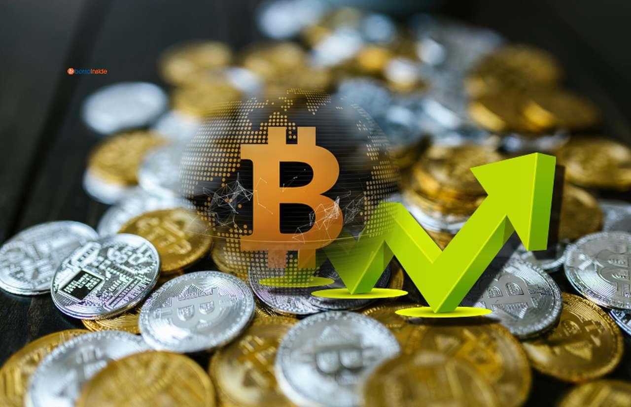 molte monete di Bitcoin d'oro e d'argento, con una freccia e il logo di Bitcoin in sovrimpressione