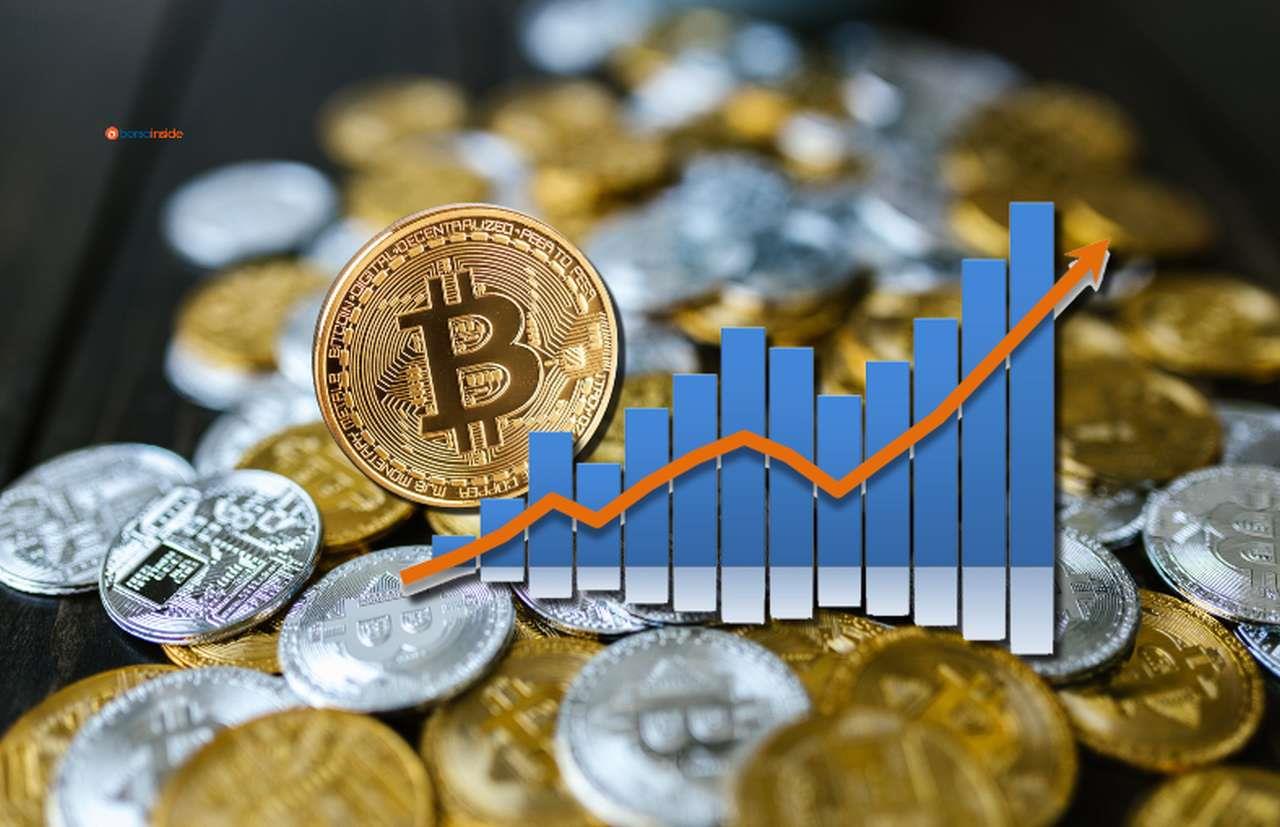 diverse monete di Bitcoin su un piano, e un grafico con freccia verso l'alto in sovrimpressione