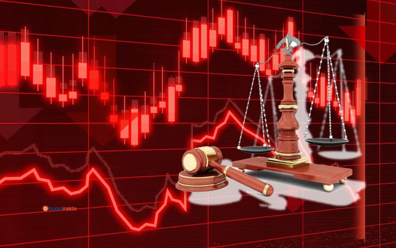 un grafico finanziario completamente in rosso e in sovrimpressione bilancia e martelletto a rappresentare la legge