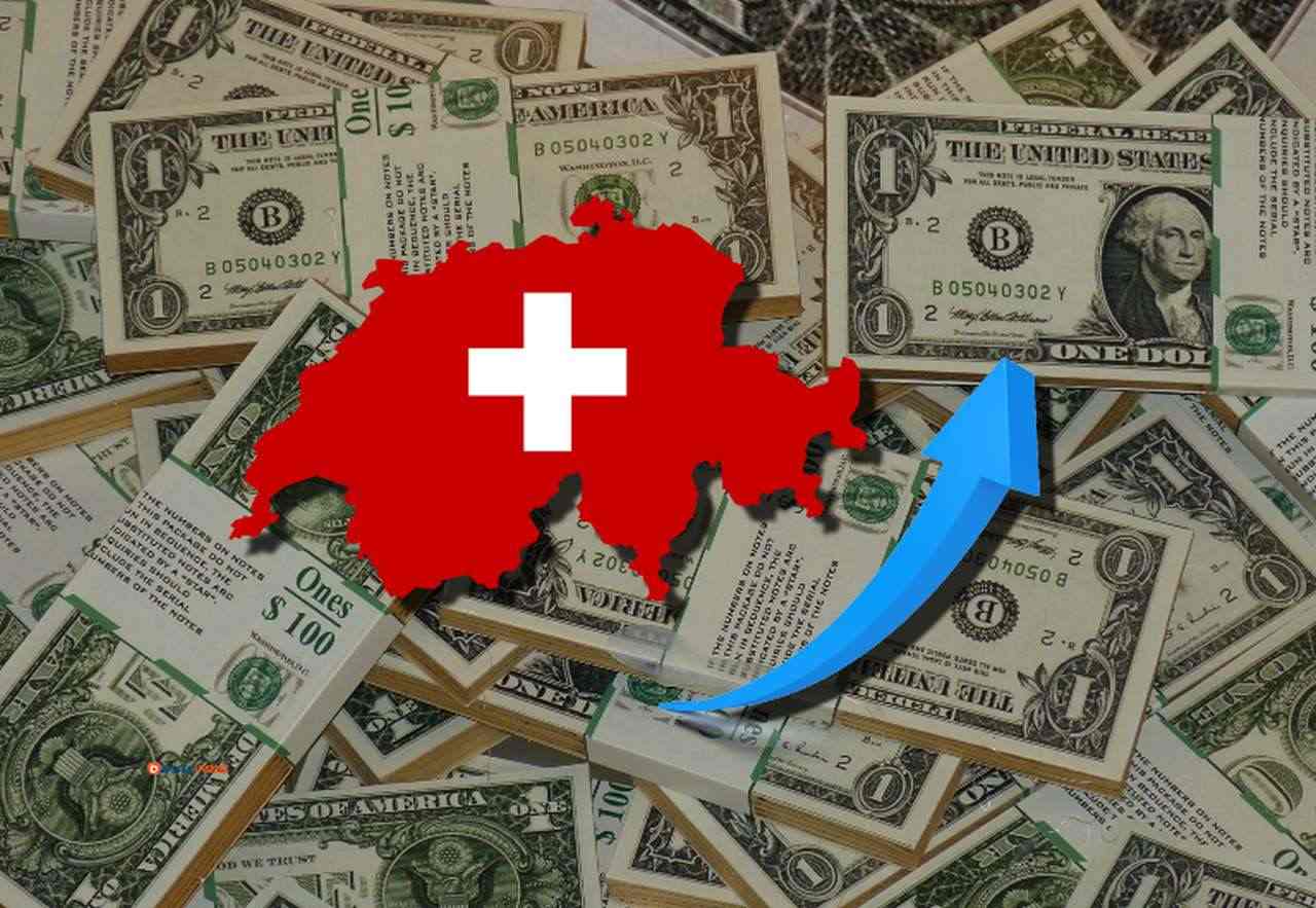 svariate banconote di dollari disposte su un piano, e la bandiera della Svizzera racchiusa nei confini dello Stato con una freccia in sovrimpressione
