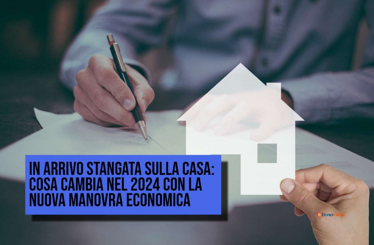 la sagoma di una casetta fatta con un foglio bianco vicino a dei documenti sui quali viene apposta una firma