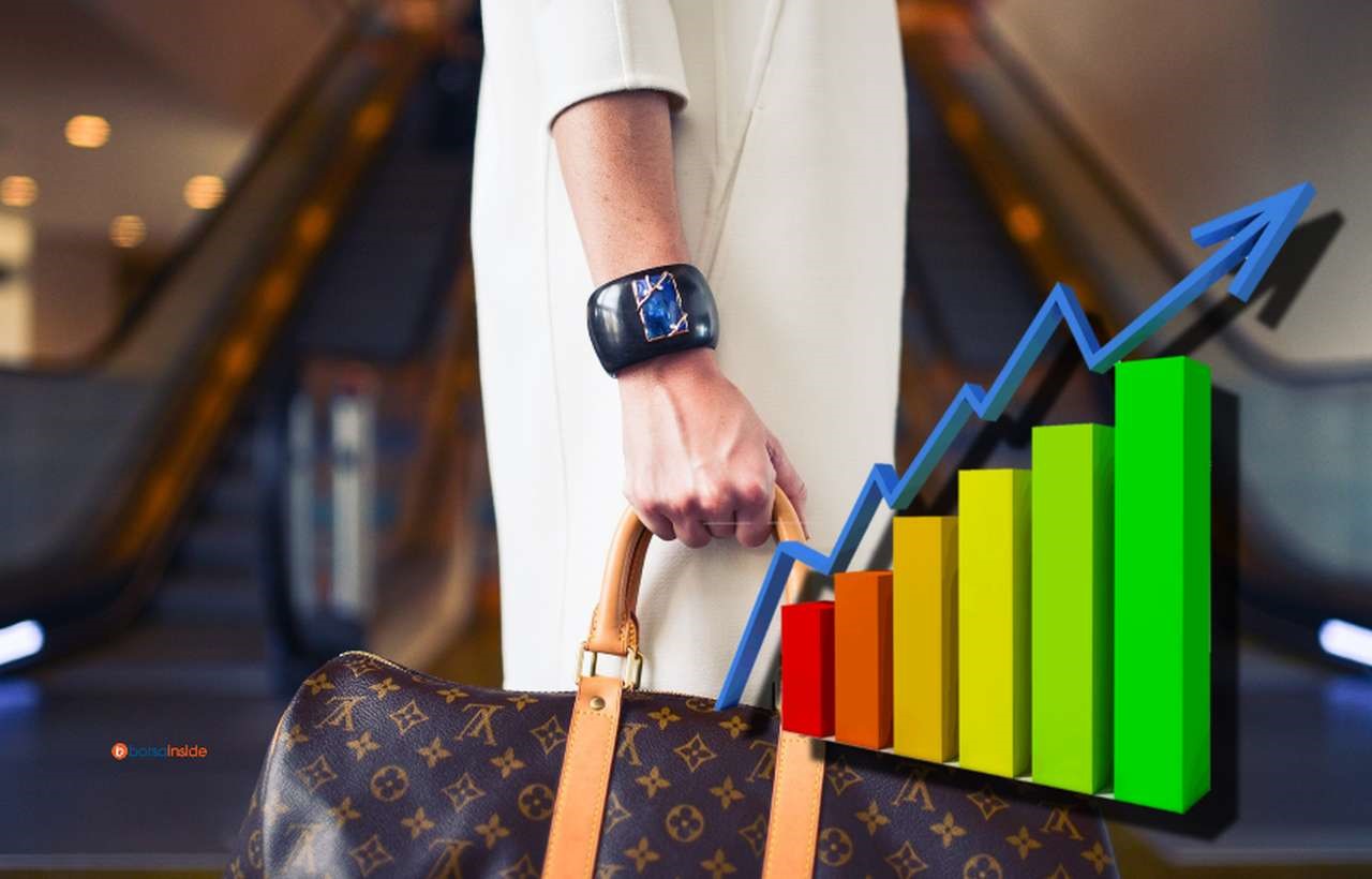 una donna elegante con una borsa griffata e un grafico con una freccia in sovrimpressione