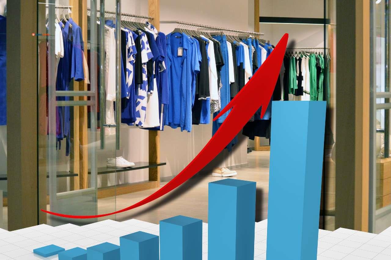 alcuni capi d'abbigliamento in un negozio e un grafico a candele con una freccia in sovrimpressione