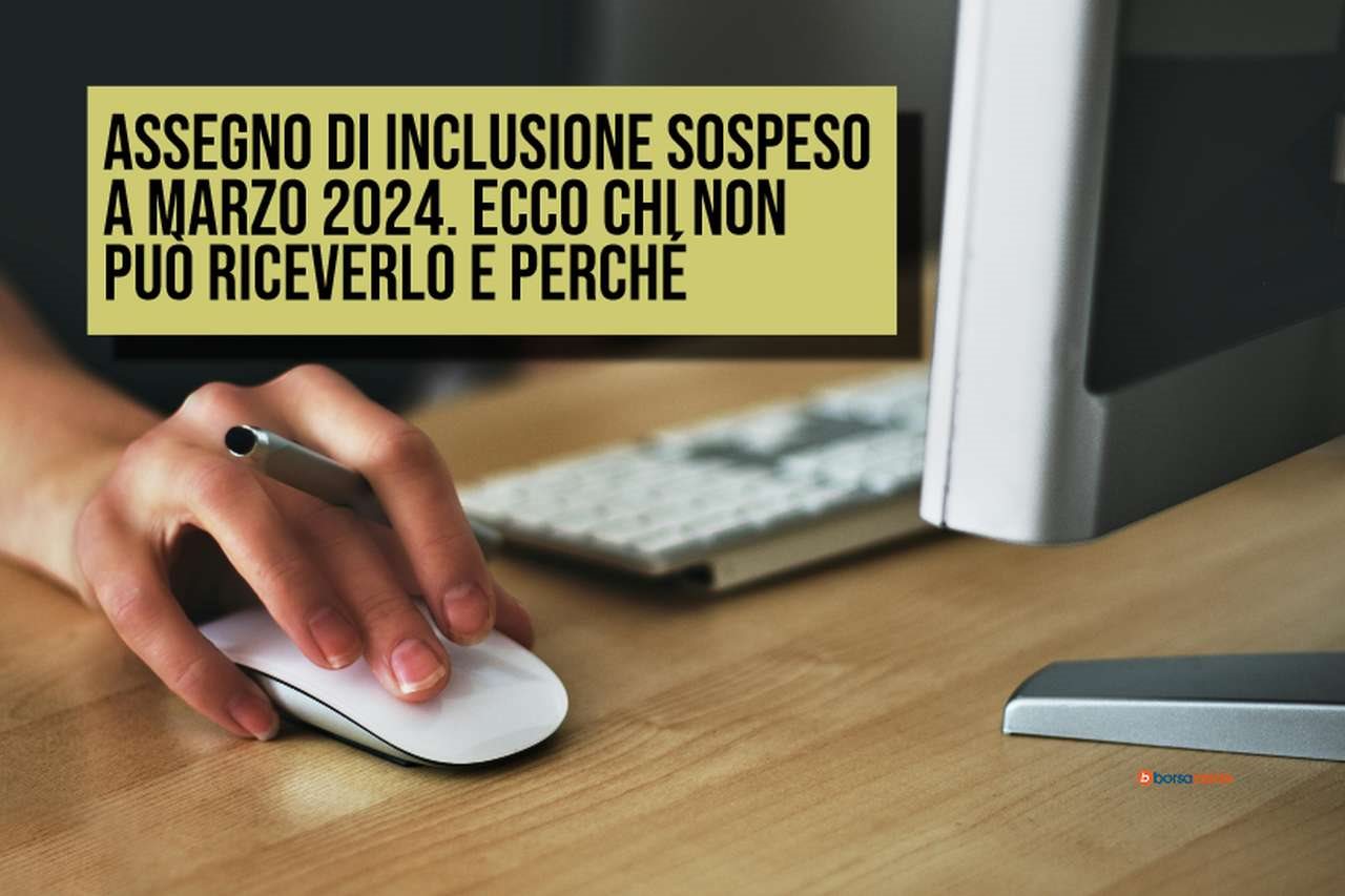 La mano di una donna sul mouse, vicino alla tastiera e allo schermo di un pc