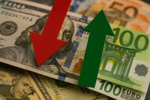 Banconote di dollaro e di euro con una freccia rossa in corrispondenza della prima e una verde della seconda
