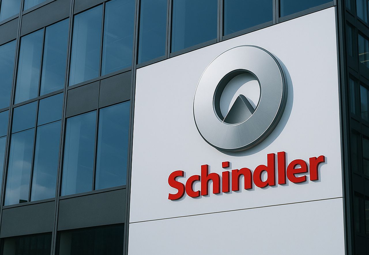 Un'insegna con logo e scritta Schindler e un palazzo sullo sfondo