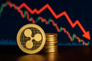 Una moneta di XRP con una piccola pila di monete accanto e un grafico a candele sullo sfondo con una freccia che ne accompagna il percorso verso il basso