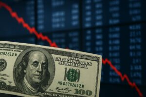 Una banconota da 100 dollari e un grafico in discesa sullo sfondo