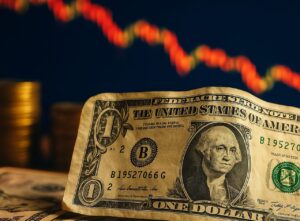 Una banconota da un dollaro con un grafico a candele sullo sfondo