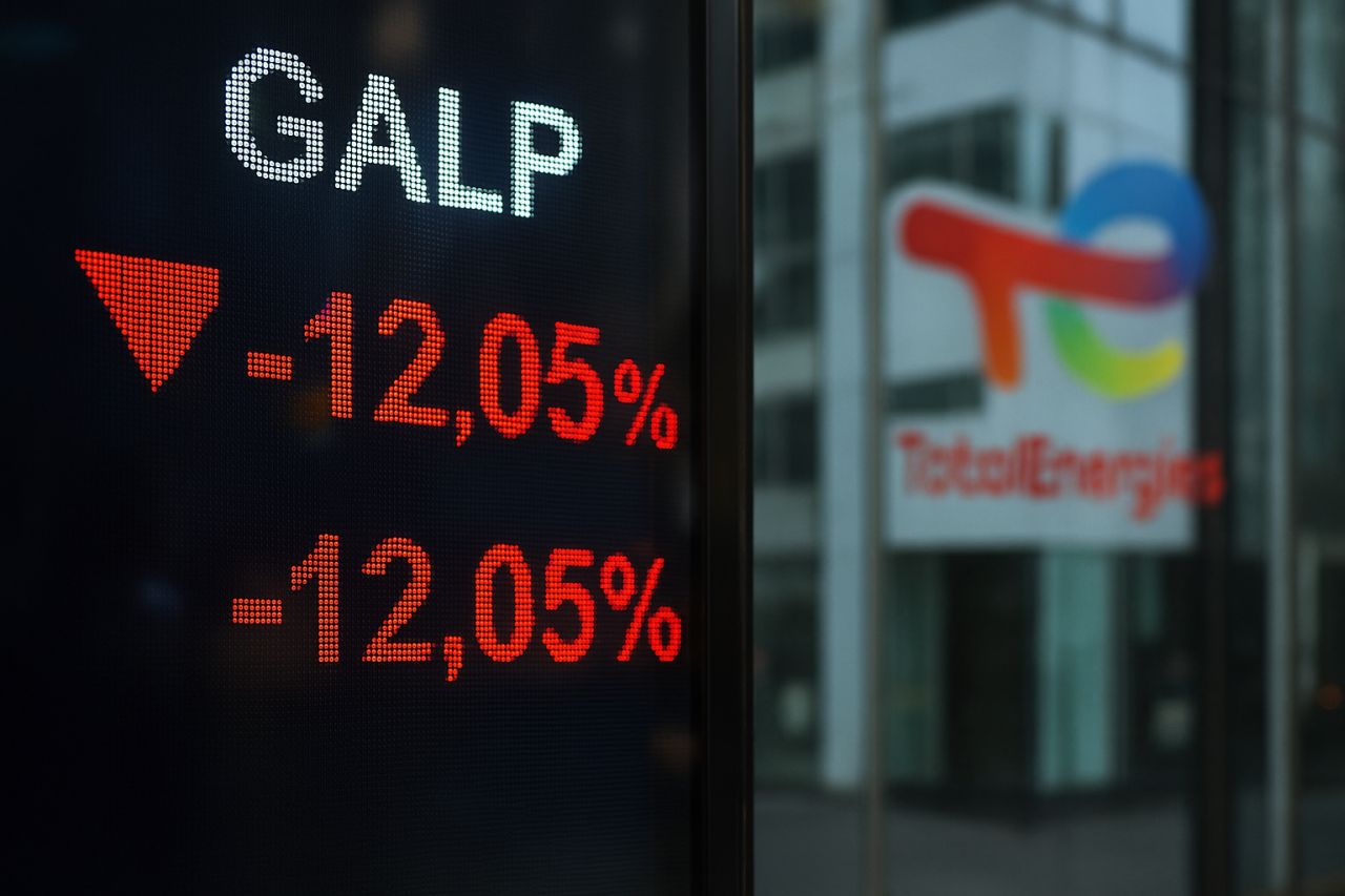Uno schermo con la scritta GALP e l'andamento del titolo. Sullo sfondo una vetrina con il logo Total Energies