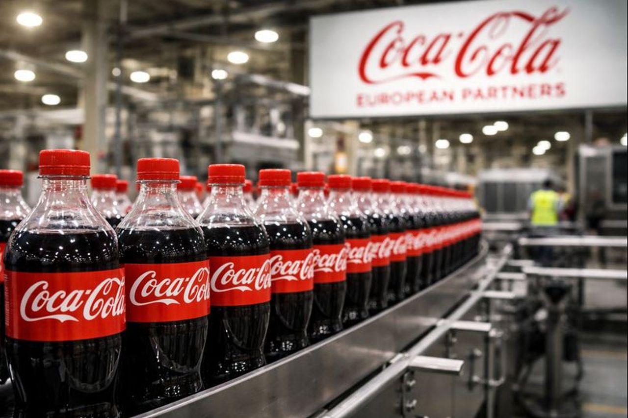 Numerose bottiglie di Coca Cola su un nastro trasportatore