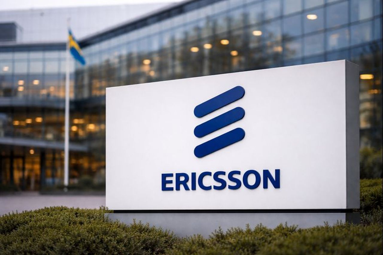 logo Ericsson su totem pubblicitario bianco di fronte a un moderno edificio