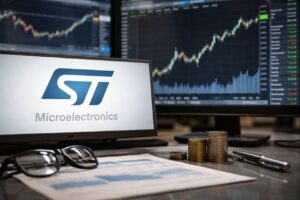 Lo schermo di un pc con il logo STM. Sullo sfondo altri schermi con grafici finanziari