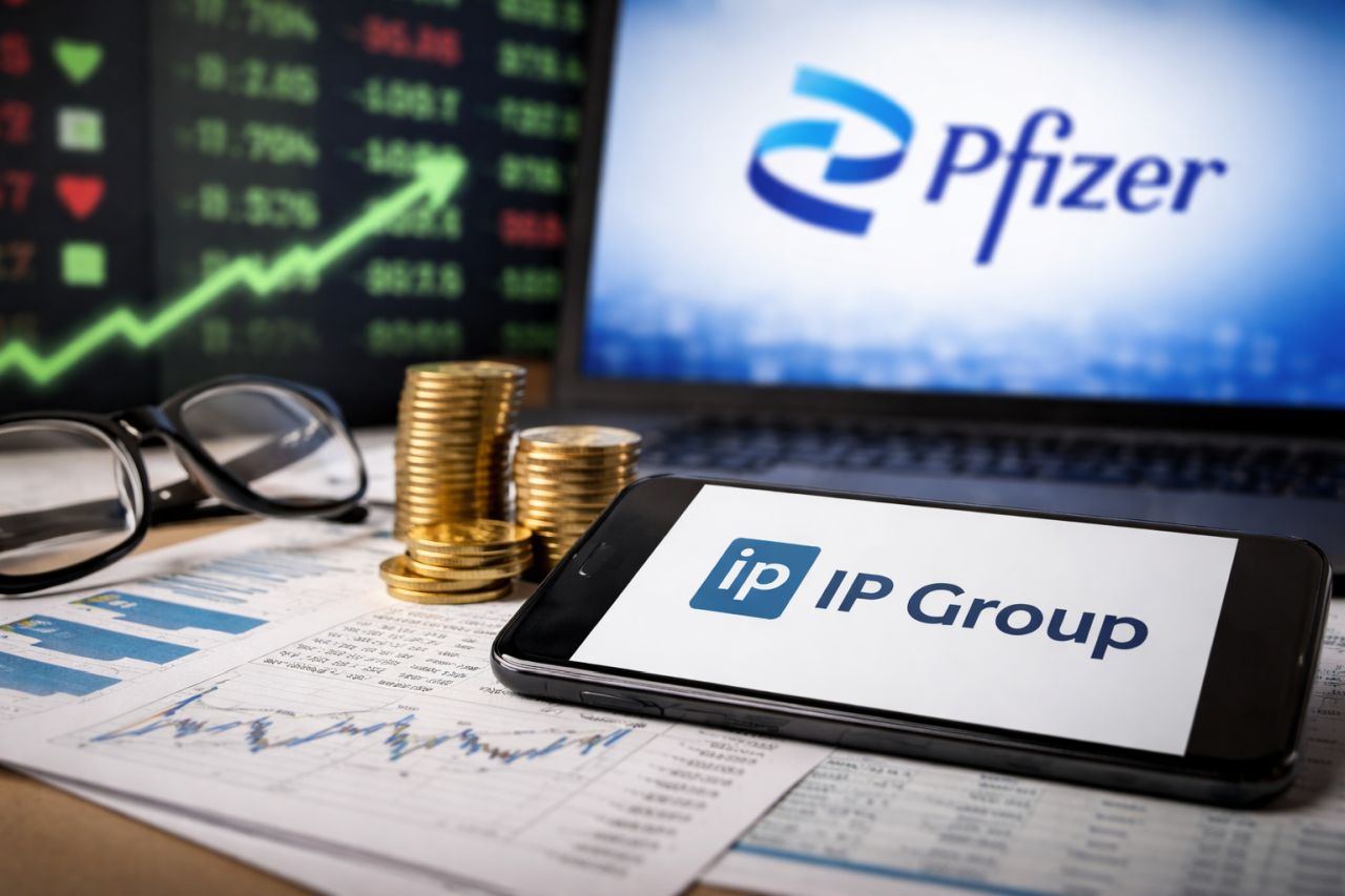 Scrivania finanziaria con smartphone (IP Group), monitor con logo Pfizer e grafico in crescita sullo sfondo