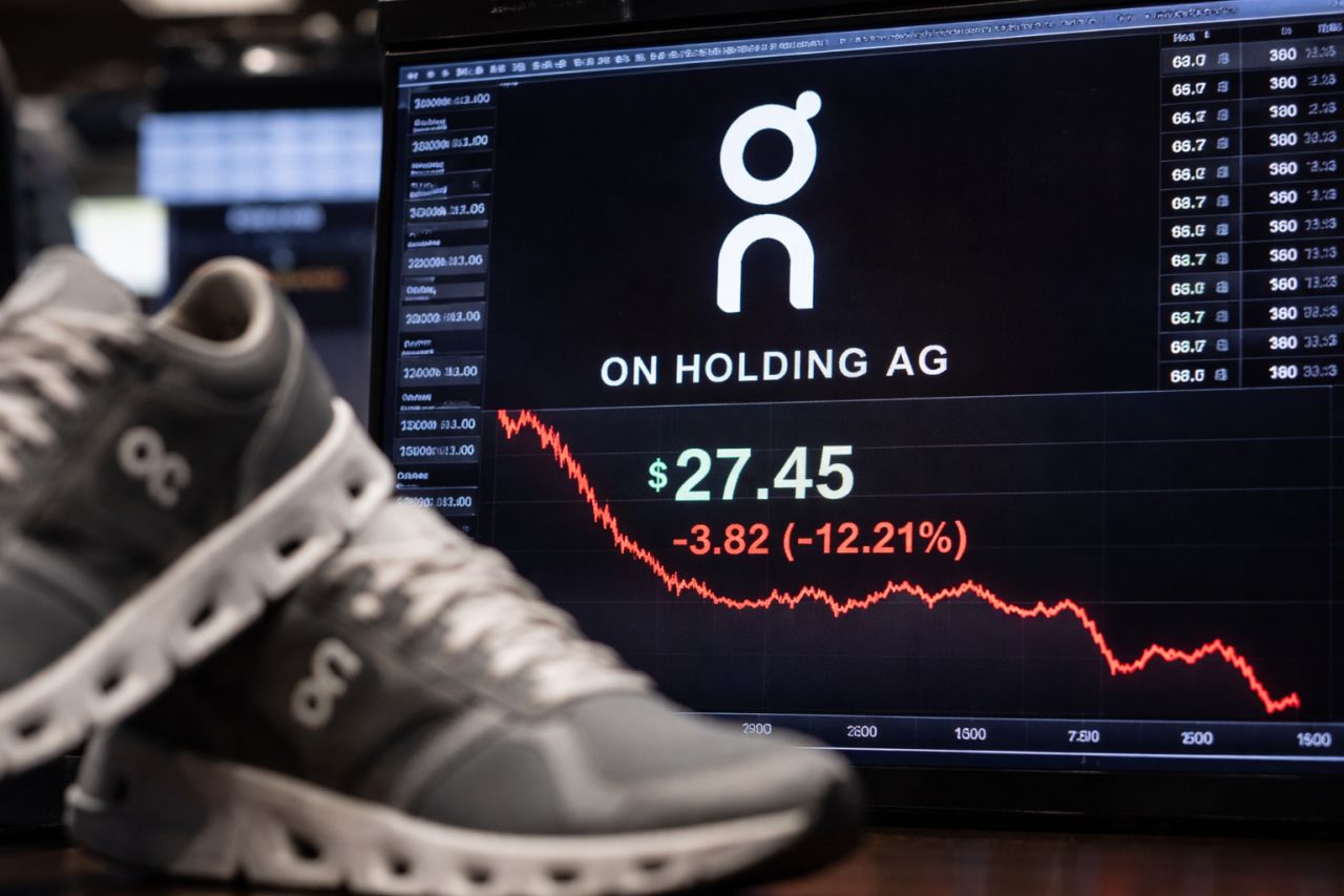 Schermo di trading con il titolo On Holding in forte calo e grafico rosso in discesa, in primo piano una scarpa sportiva sfocata